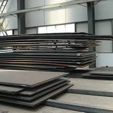 Large steel plates stacked inside industrial warehouse for fabrication use